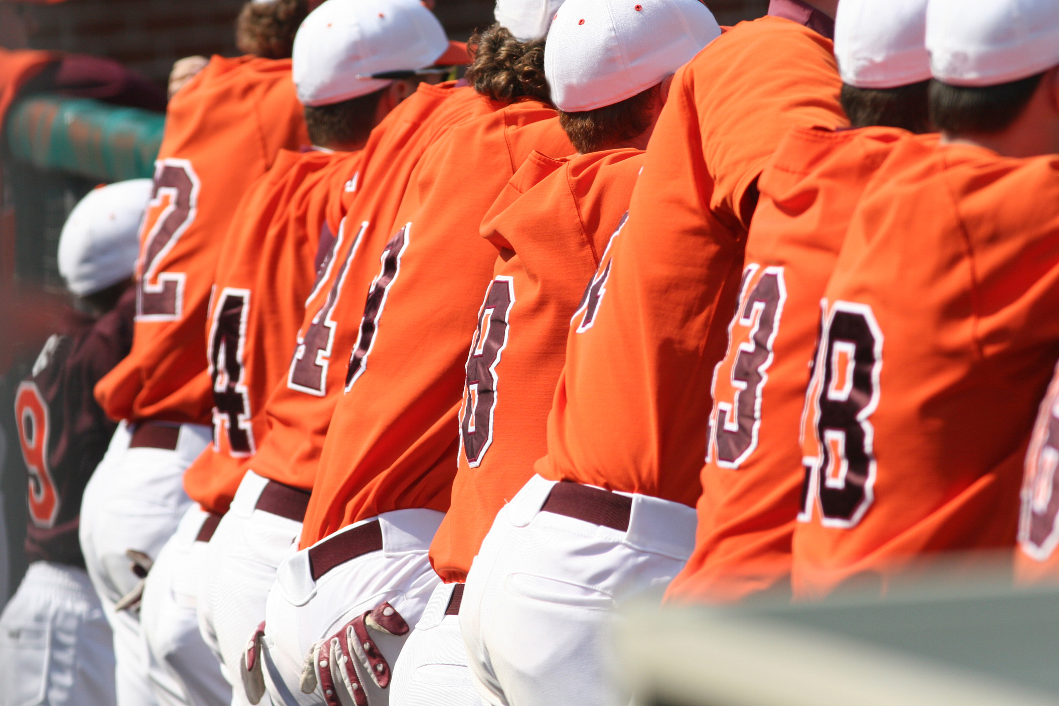Back view of a baseball team in orange uniforms